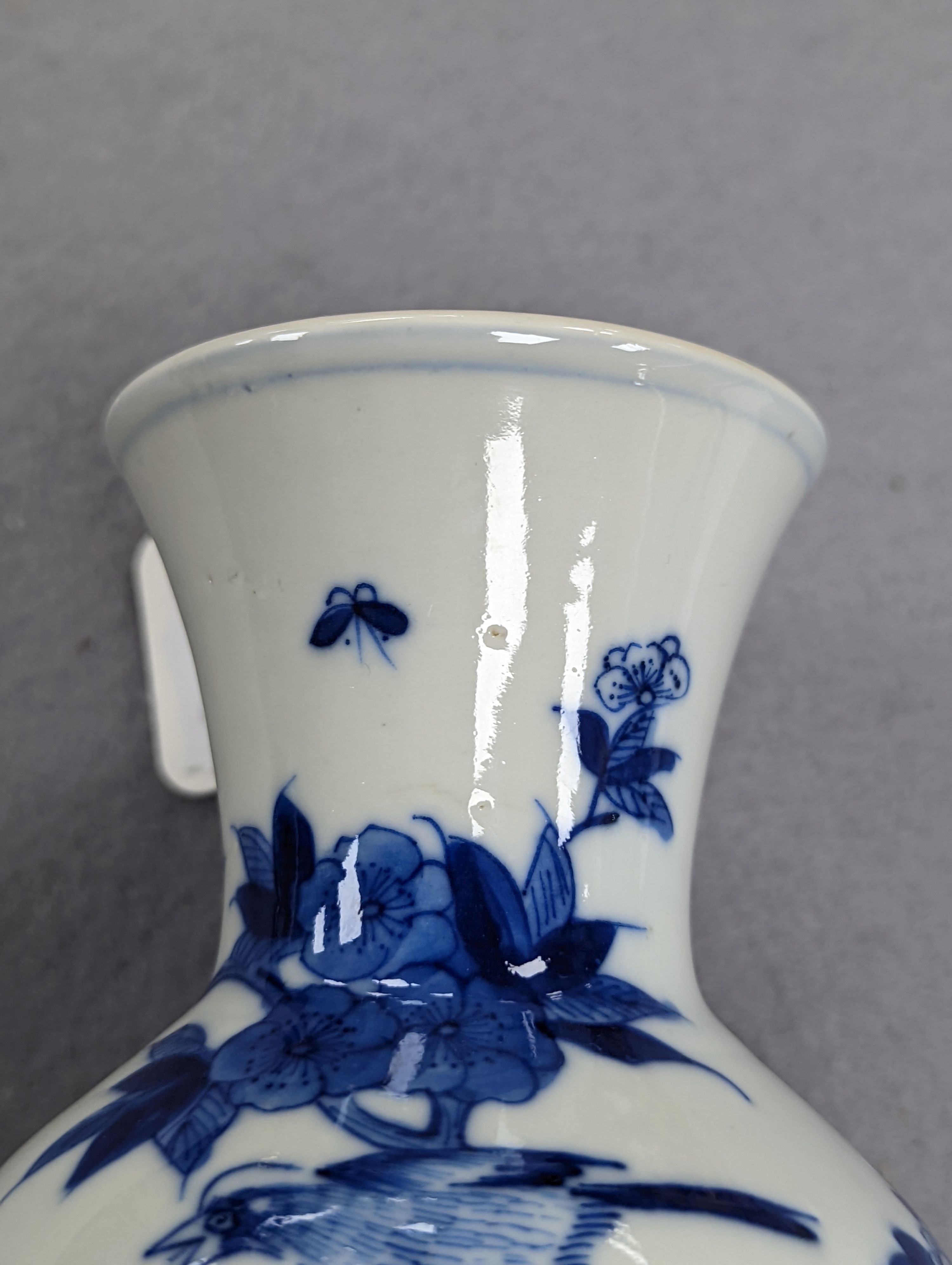 A late 19th century Chinese blue and white baluster vase, painted with birds amid flowers and rock work, pseudo Kangxi mark. 26cm